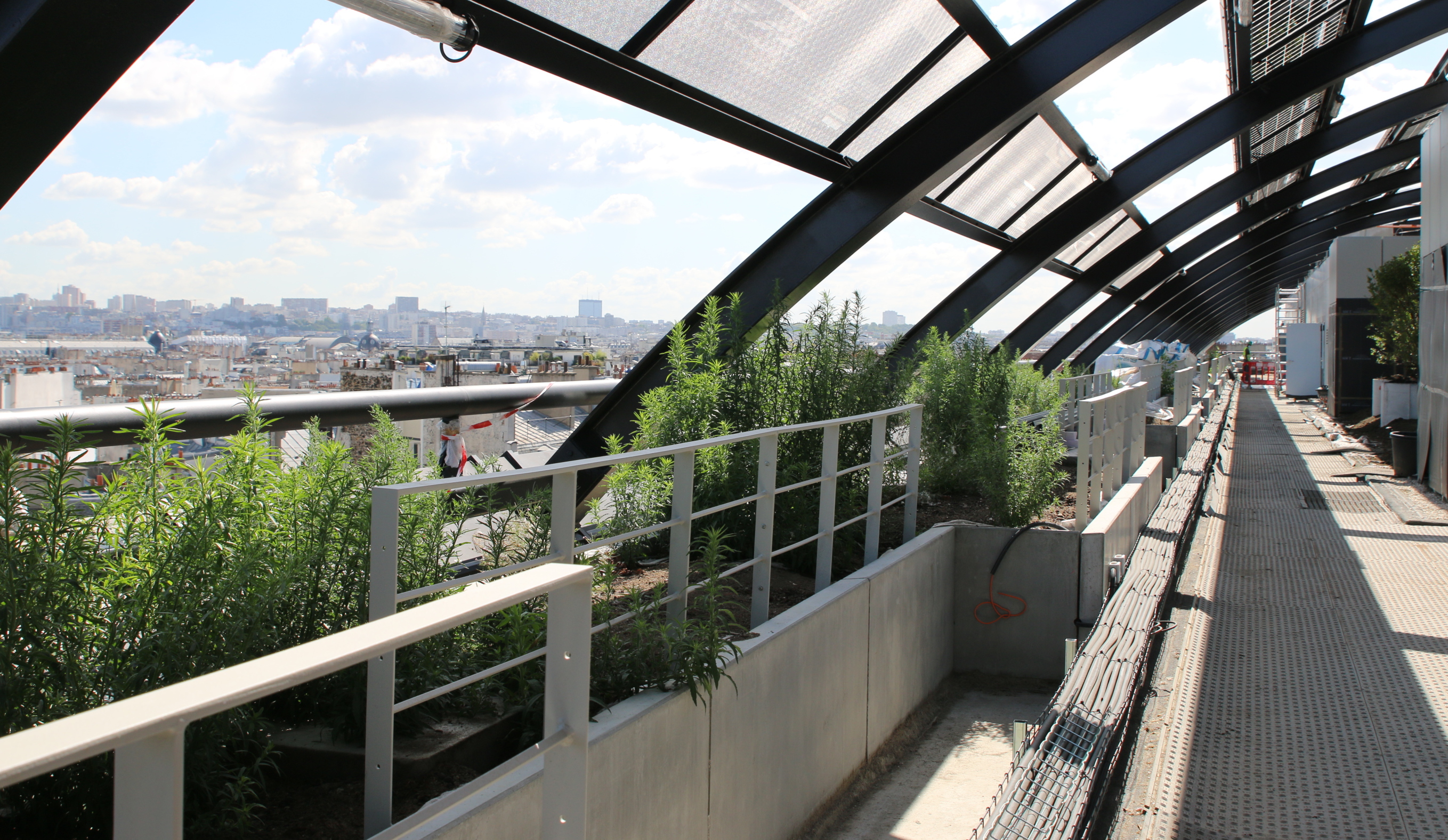 De l’extérieur vers l’intérieur, la toiture-terrasse du bâtiment est agrémentée de jardinières en périphérie, d’une ceinture circulable en platelage bois et du jardin arboré côté cours.