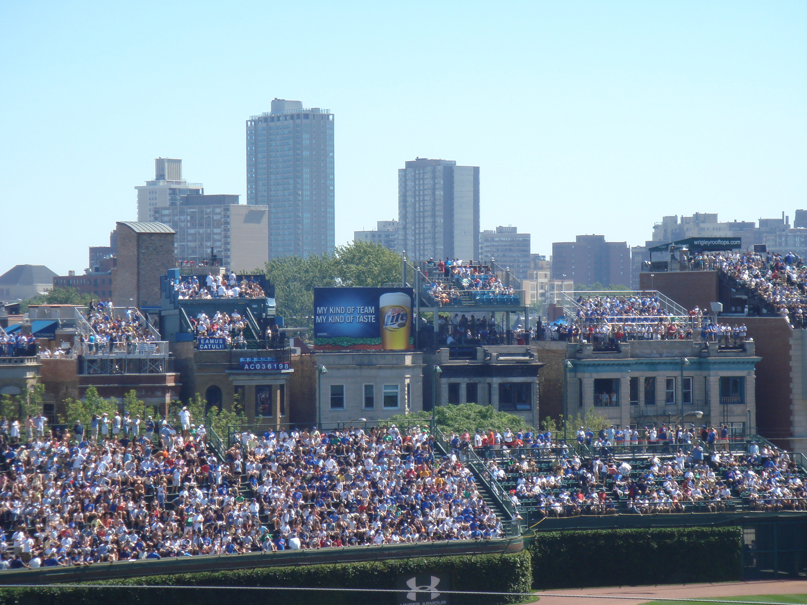 Assister aux matchs sur les toits : c’est la solution qu’ont trouvé les riverains du stade de baseball Wrigley Field de Chicago pour profiter du spectacle à moindre frais. Une poule aux œufs d’or pour les propriétaires des lieux qui, à mesure que le succès croit, en monnayent l’accès. Nous sommes alors dans les années 1980. Des gradins métalliques sont installés en toiture. Evidemment, la direction du stade ne voit pas d’un très bon œil cette concurrence et va même en 2002 jusqu’à mettre en œuvre des écrans brise-vue et poursuivre les propriétaires en justice. Finalement, après négociations, un compromis est trouvé. Mais, en 2014, le nouvel acquéreur du stade relance une procédure qui reste sans suite. Pour clore définitivement le débat, le club de baseball rachète 11 des 16 immeubles concernés. 