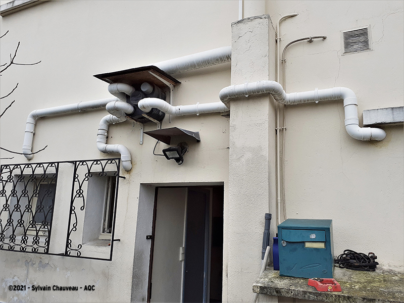 VMC fixée à l’extérieur, en façade nord, sans isolation thermique, exposée au gel et à la condensation interne. Important développement de moisissures dans le logement.