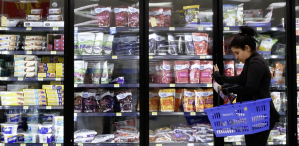 Consommatrice devant une vitrine de fruits surgelés chez Walmart...