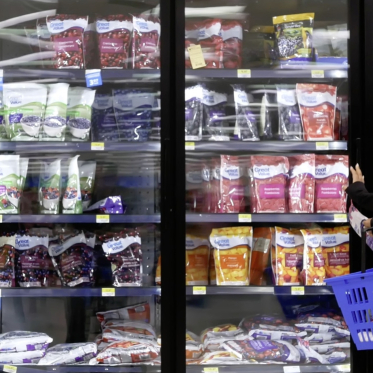 Consommatrice devant une vitrine de fruits surgelés chez Walmart...