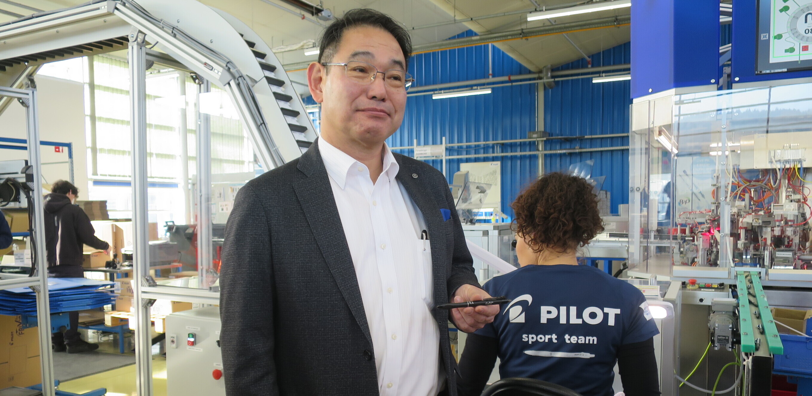 Yoshio Wada, président-directeur général de Pilot Corporation of Europe, pose avec le FriXion Ball + devant l’outil de production spécialement conçu pour sa fabrication en France. 