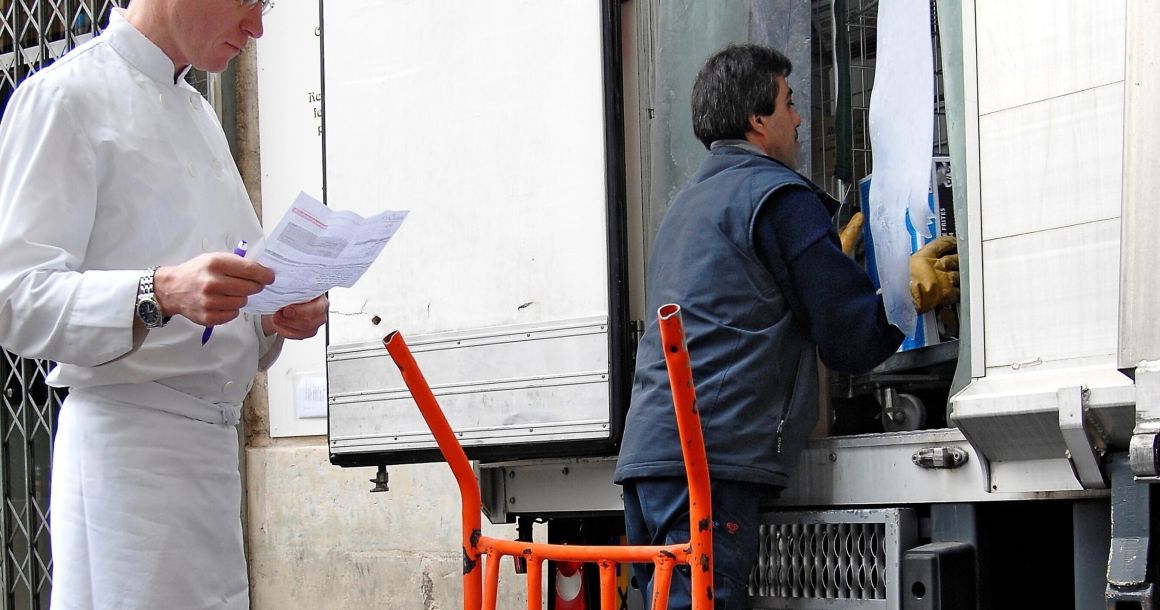 Un restaurateur indépendant en train de vérifier sa commande en cours de livraison par un grossiste.